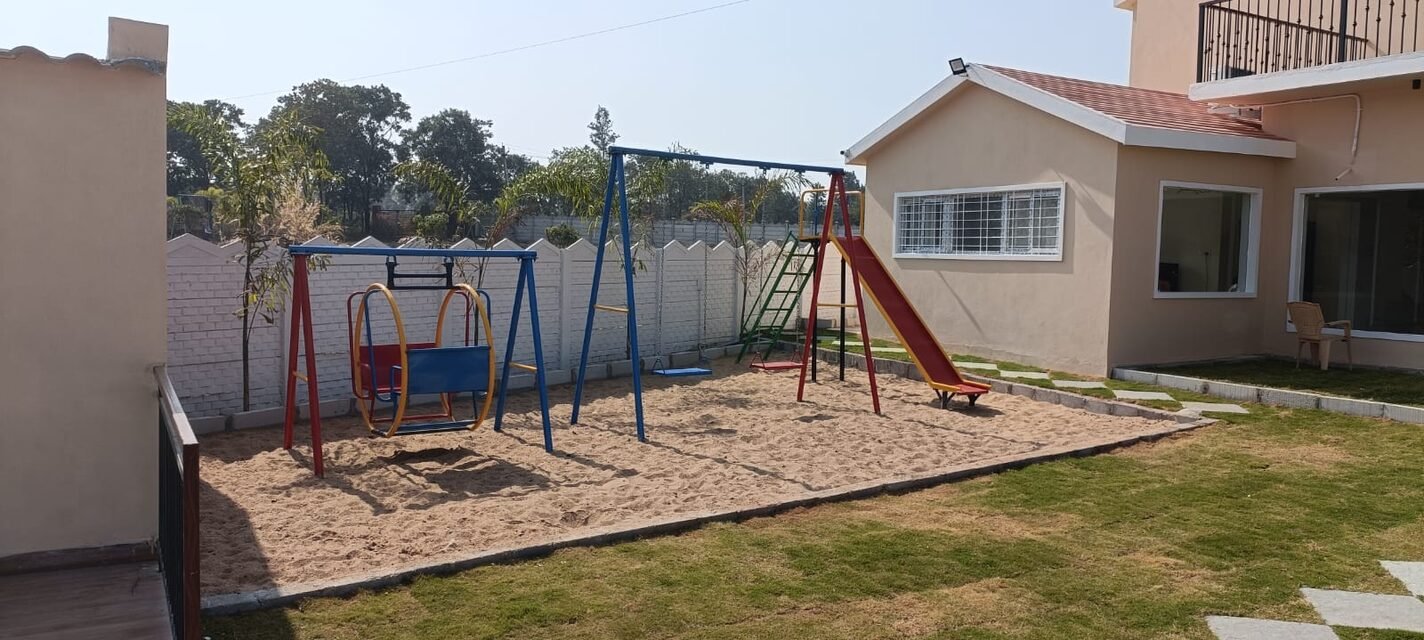 The children's play area with swings and a slide